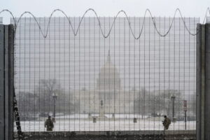 National Guard members stand in the snow on duty in front of the U.S. Capitol behind protective fencing in Washington, U.S., January 31, 2021. REUTERS/Cheriss May
