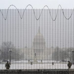 National Guard members stand in the snow on duty in front of the U.S. Capitol behind protective fencing in Washington, U.S., January 31, 2021. REUTERS/Cheriss May